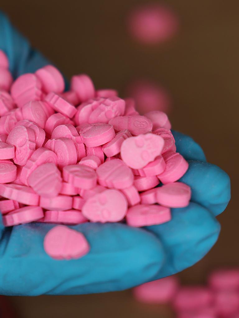 Eine Person hält Ecstasy-Tabletten in der Hand. 