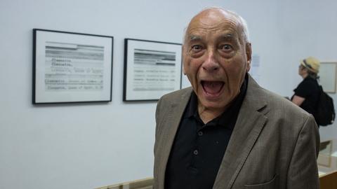 Der Dichter Eugen Gomringer steht mit weit geöffnetem Mund im haus der Posie