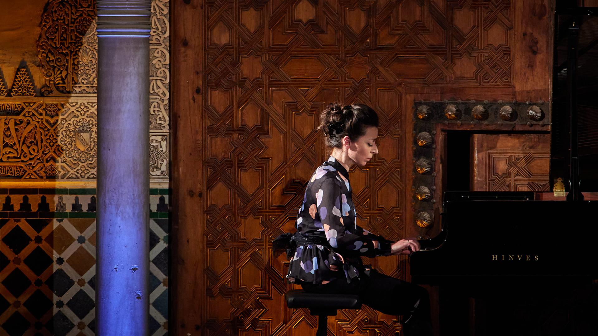 Auf dem Bild ist eine Frau im Profil zu sehen, die Klavier spielt. Es ist die Pianistin Yulianna Avdeeva. 