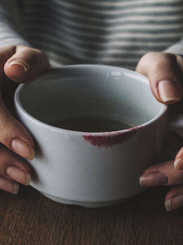 MIDSECTION OF WOMAN WITH COFFEE CUP