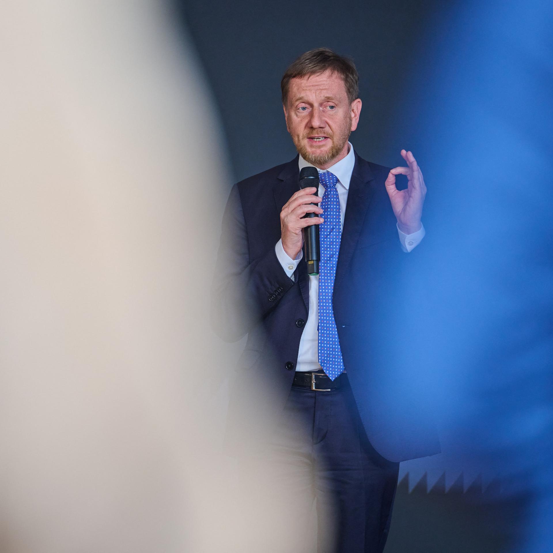 Michael Kretschmer (CDU), Ministerpräsident von Sachsen, spricht bei einem Richtfest in Dresden in ein Mikrofon und gestikuliert.