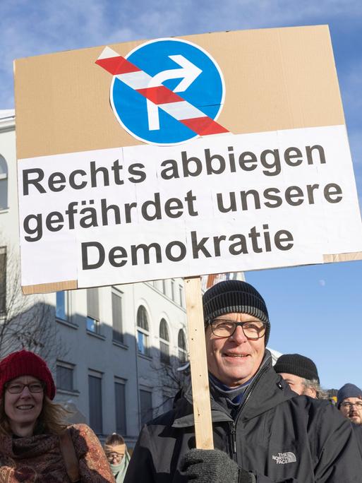 Protestierende bei einer Demonstration in Erfurt gegen rechts. Man sieht ein Schild mit der Aufschrift: "Rechts abbiegen gefährdet unsere Demokratie"