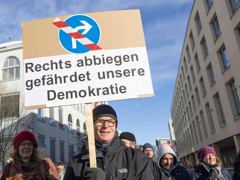 Protestierende bei einer Demonstration in Erfurt gegen rechts. Man sieht ein Schild mit der Aufschrift: "Rechts abbiegen gefährdet unsere Demokratie"