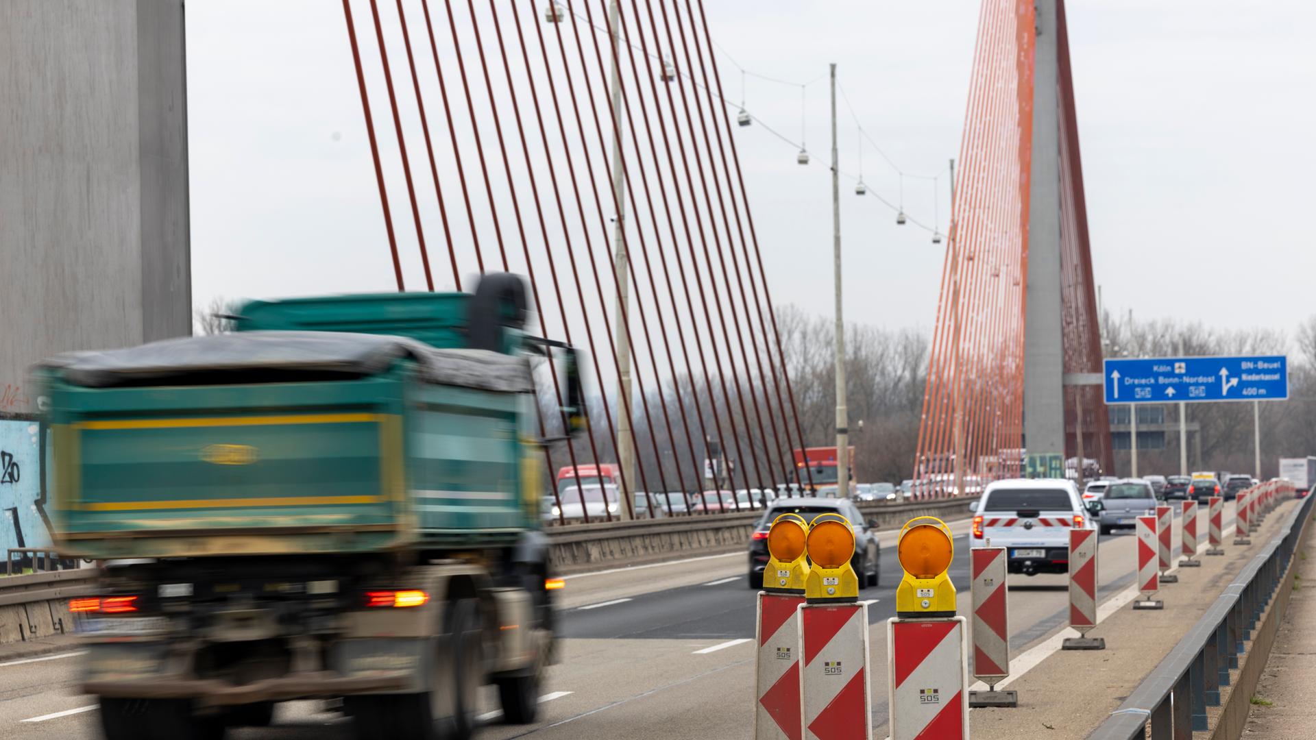 Die Bonner Nordbrücke (Friedrich-Ebert-Brücke, A565) führt über den Rhein. Mehrere Autos und ein Lkw fahren darüber.