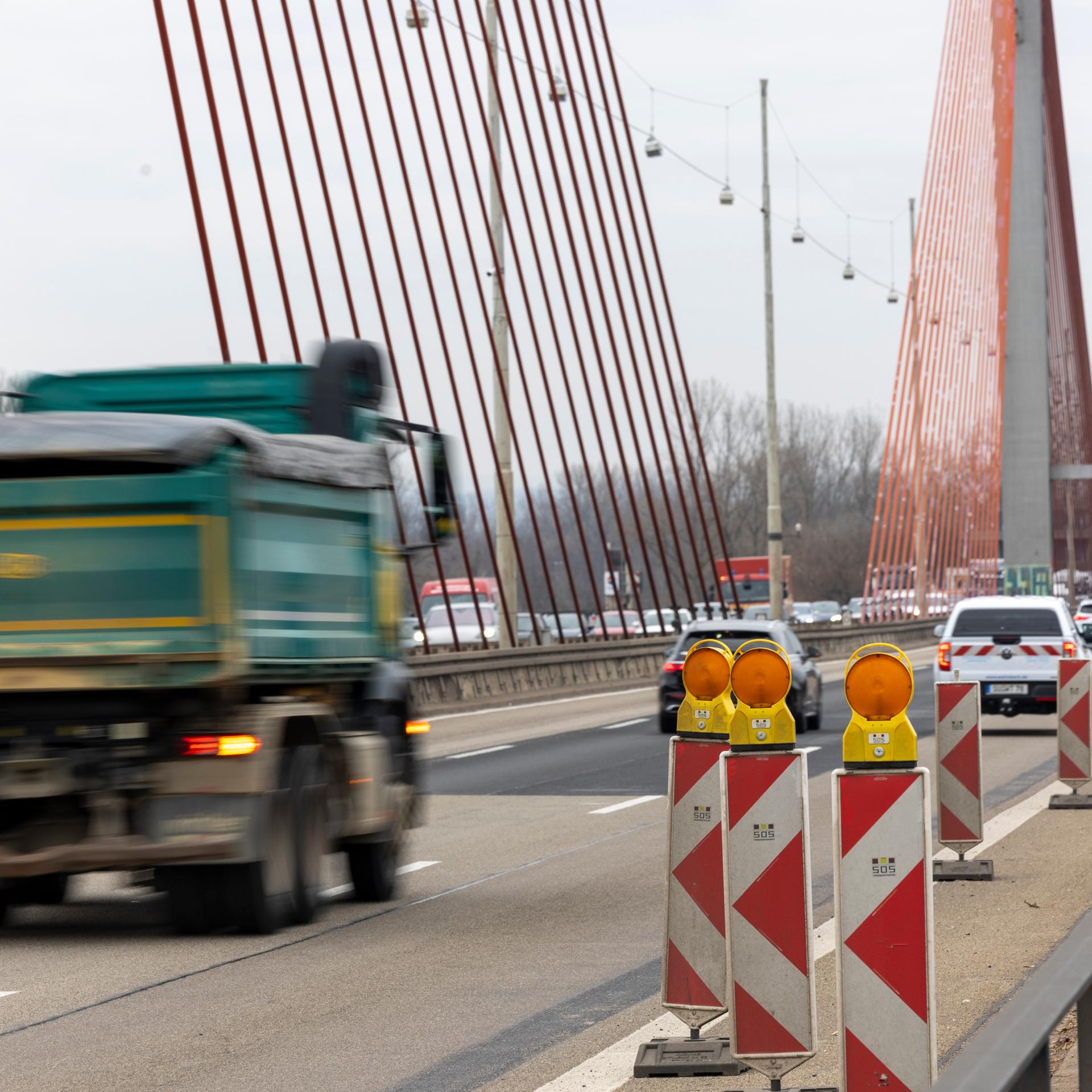 Die Bonner Nordbrücke (Friedrich-Ebert-Brücke, A565) führt über den Rhein. Mehrere Autos und ein Lkw fahren darüber.