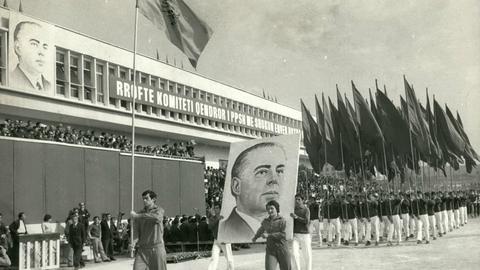Historische Aufnahme aus Dezember 1977: Studenten marschieren mit Fahnen zur Feier des 20-jährigen Bestehens der Universität Tirana. Zwei Männer tragen zudem ein großes Plakat mit dem Konterfei von Enver Hoxha, dem damaligen kommunistischen Herrscher Albaniens.