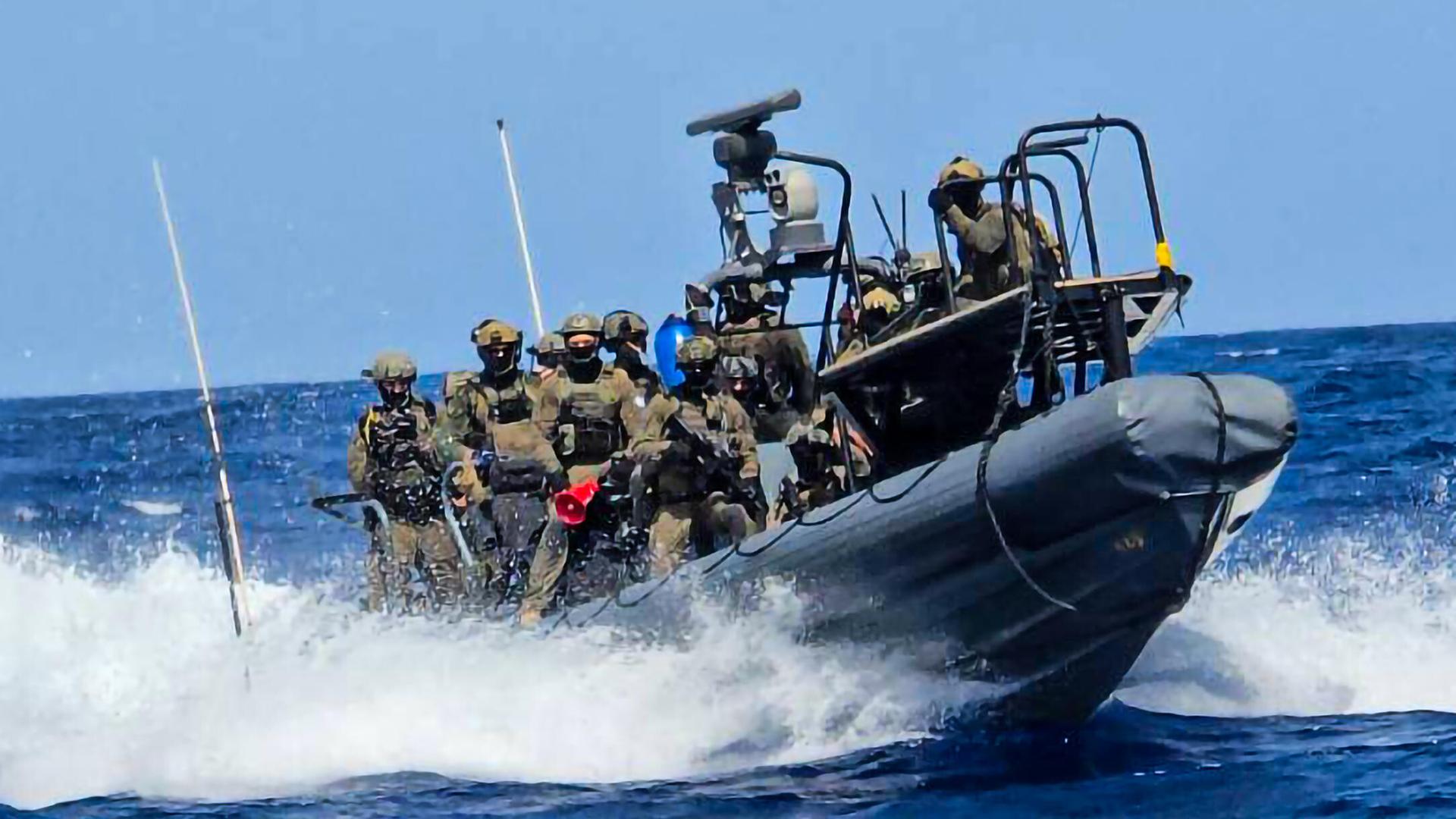 Mehrere Soldaten des israelischen Militärs stehen auf einem Boot, welches in voller Fahrt ist. Mehrere Soldaten des israelischen Militärs stehen auf einem Boot, welches in voller Fahrt ist.