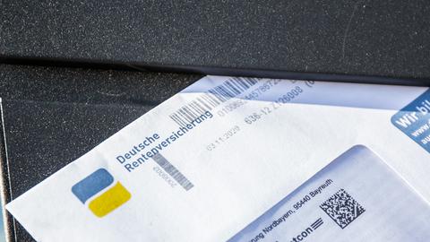 Ein Brief der Deutschen Rentenversicherung steckt in einem Briefkasten.