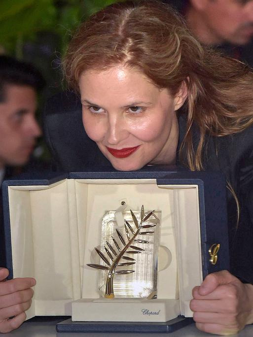 Die französische Filmemacherin Justine Triet hält ihre "Goldene Palme" 