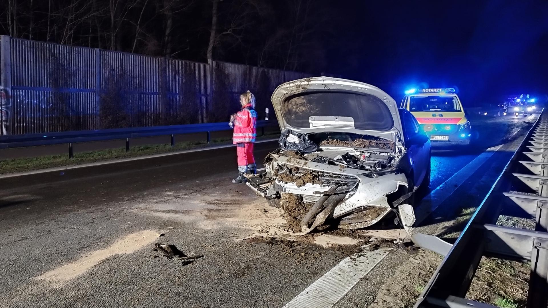 Ein kaputtes Auto steht auf der Bundesstraße 5, daneben steht ein Rettungsfahrzeug und eine Einsatzkraft.