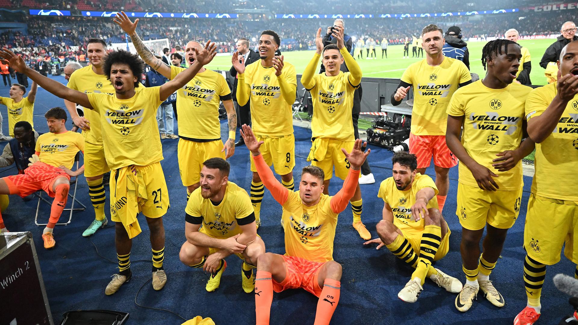 Die Spieler von Borussia Dortmund stehen und knien nach dem Spiel gegen Paris vor der Tribüne und jubeln mit ihren Fans über den Einzug ins Finale der Fußball-Champions-League Die Spieler von Borussia Dortmund stehen und knien nach dem Spiel gegen Paris vor der Tribüne und jubeln mit ihren Fans über den Einzug ins Finale der Fußball-Champions-League
