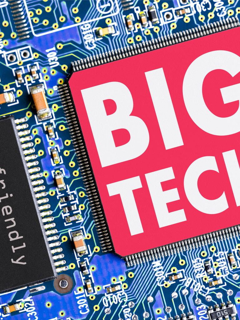 Eine blaue Platine mit Halbleitern und zwei Chips. Einer traegt die Aufschrift "unfriendly takeover", der andere, groessere hat die Aufschrift "BIG TECH". Eine blaue Platine mit Halbleitern und zwei Chips. Einer traegt die Aufschrift "unfriendly takeover", der andere, groessere hat die Aufschrift "BIG TECH".