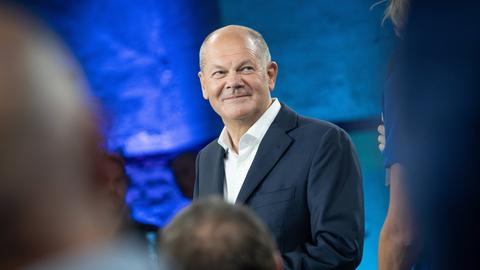 Bundeskanzler Olaf Scholz steht bei einem Bürgerdialog in Bremen inmitten des Publikums.