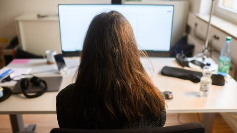 Ein Frau sitzt an einem Arbeitsplatz vor einem Computer (gestellte Szene). Ein Frau sitzt an einem Arbeitsplatz vor einem Computer (gestellte Szene).