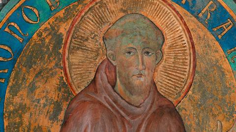 Mittelalterliches, farbenfrohes Fresko von Franz von Assisi mit einem Heiligenschein