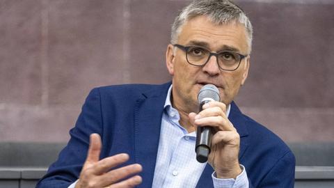 Stefan Kornelius spricht in einem blauen Anzug in ein Mikrofon.