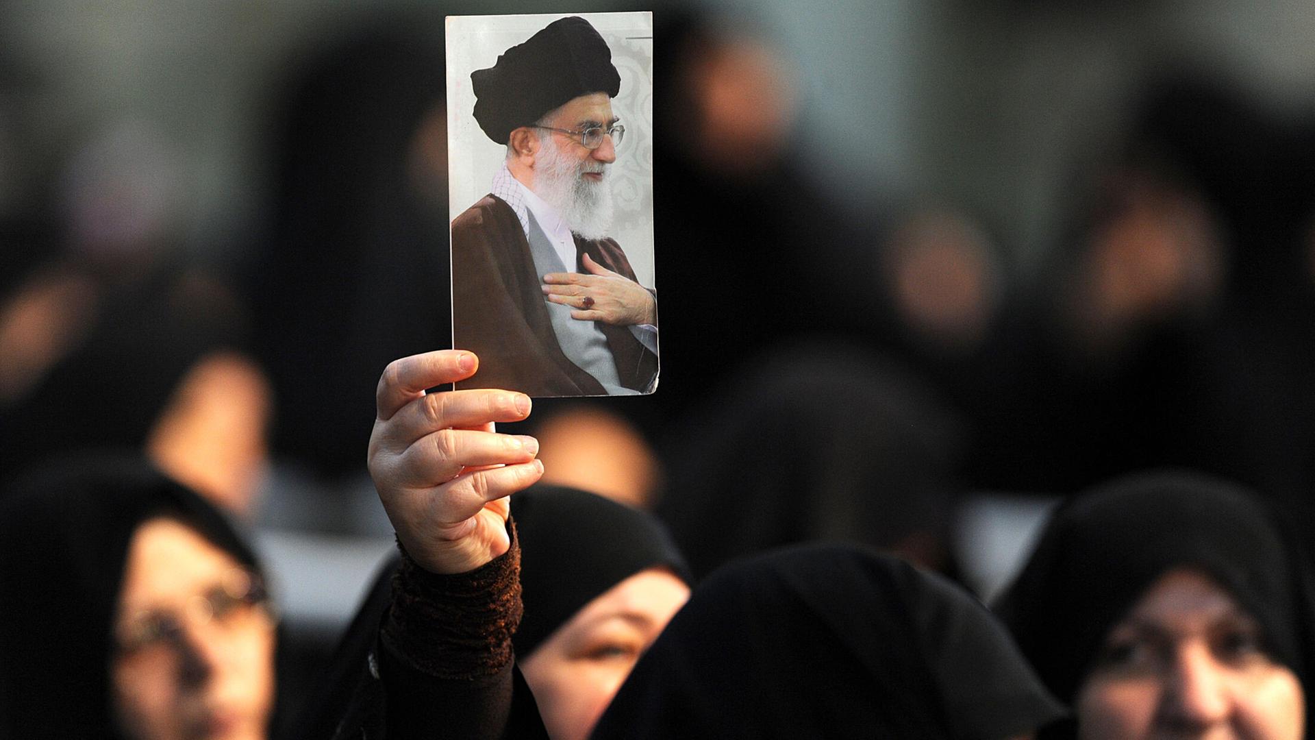 Frauen halten ein Bild von Ayatollah Ali Chamenei hoch Frauen halten ein Bild von Ayatollah Ali Chamenei hoch