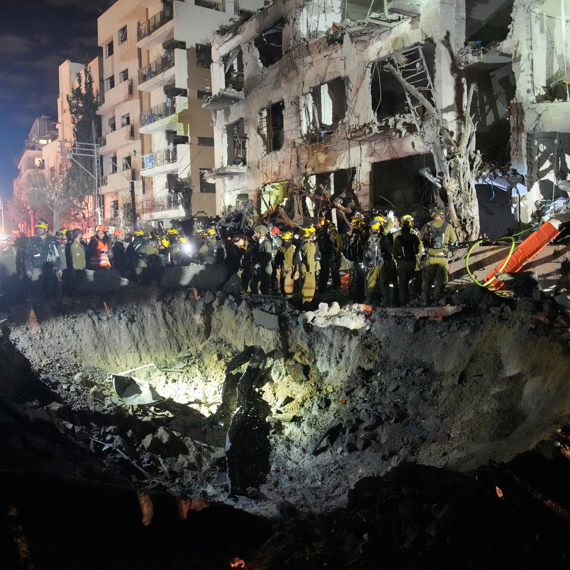 Beamte des israelischen Heimatfrontkommandos durchsuchen die Trümmer eines beschädigten Wohnhauses nach einem iranischen Raketenangriff in Tel Aviv.