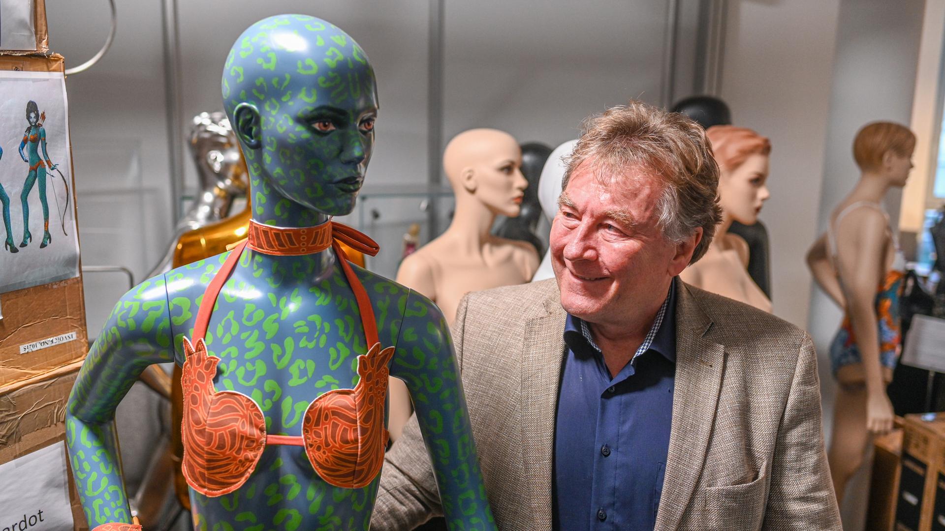 Der Unternehmer Alexander Ruscheinsky steht bei der Eröffnung seines Museums für Bademode und Badekultur neben einer Puppe mit einem orangen Bikini. 