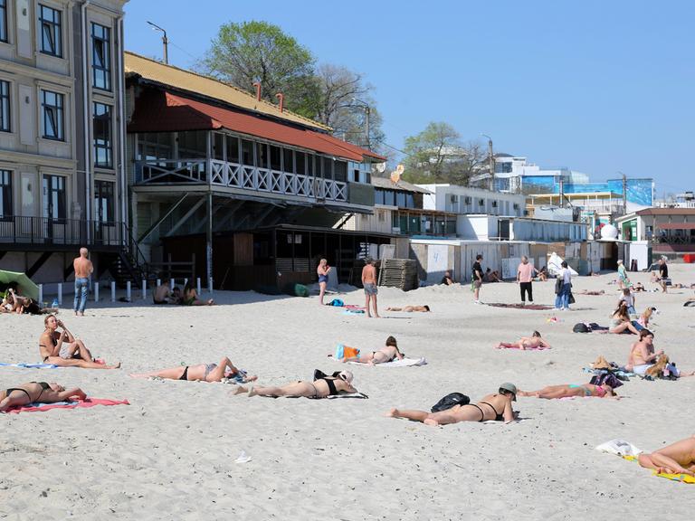 Menschen liegen auf einem Strand.