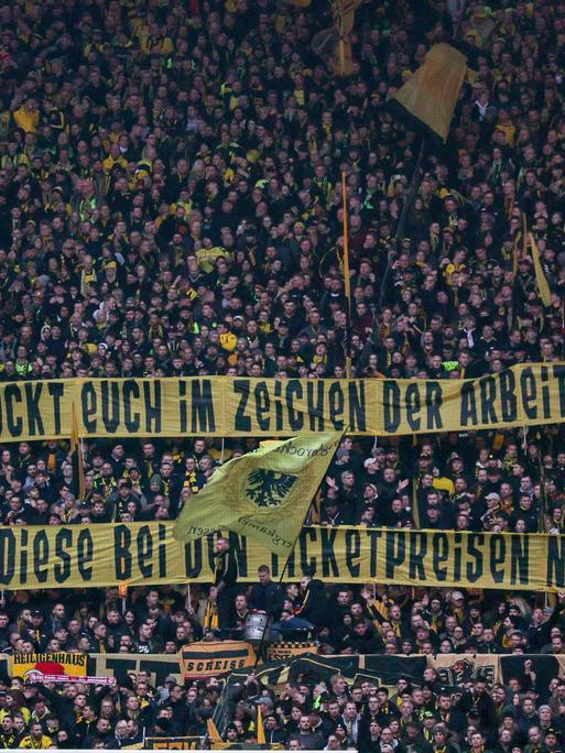 Fans von Fußball-Bundesligist Borussia Dortmund äußern mit Bannern Kritik am Sondertrikot: "Ihr schmückt euch im Zeichen der Arbeiterschaft, vergesst diese bei den Ticketpreisen nicht!"