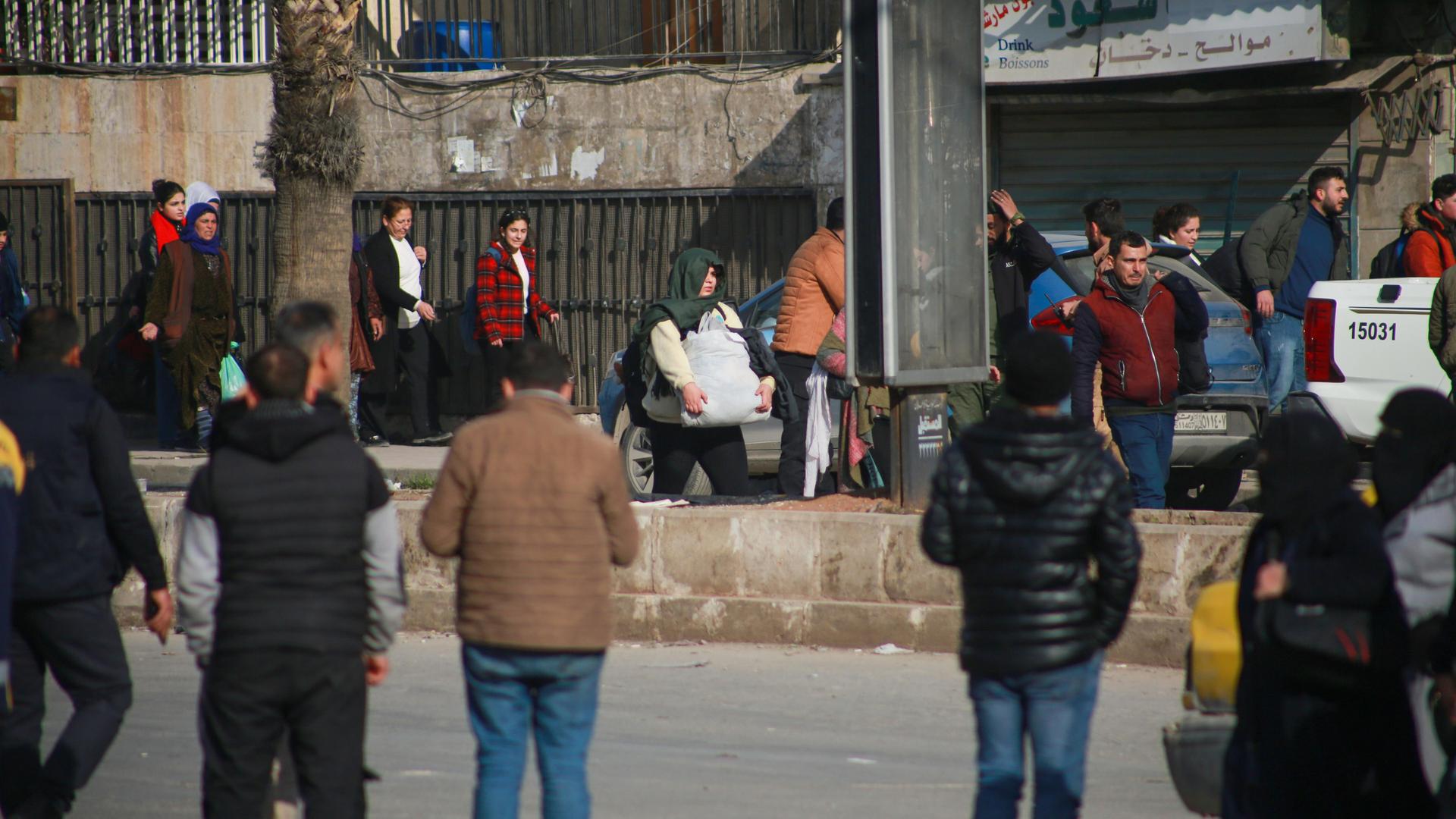 Einwohner von Aleppo flüchten bepackt mit Taschen aus der Stadt. Einwohner von Aleppo flüchten bepackt mit Taschen aus der Stadt.
