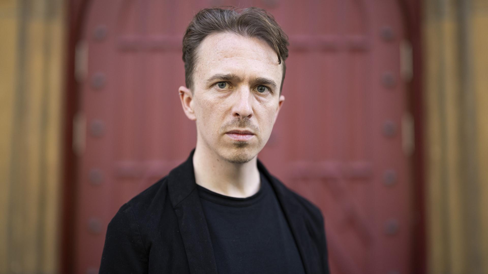 Der Schweizer Schriftsteller Béla Rothenbuehler posiert vor einem Tor. Der Schweizer Schriftsteller Béla Rothenbuehler posiert vor einem Tor.
