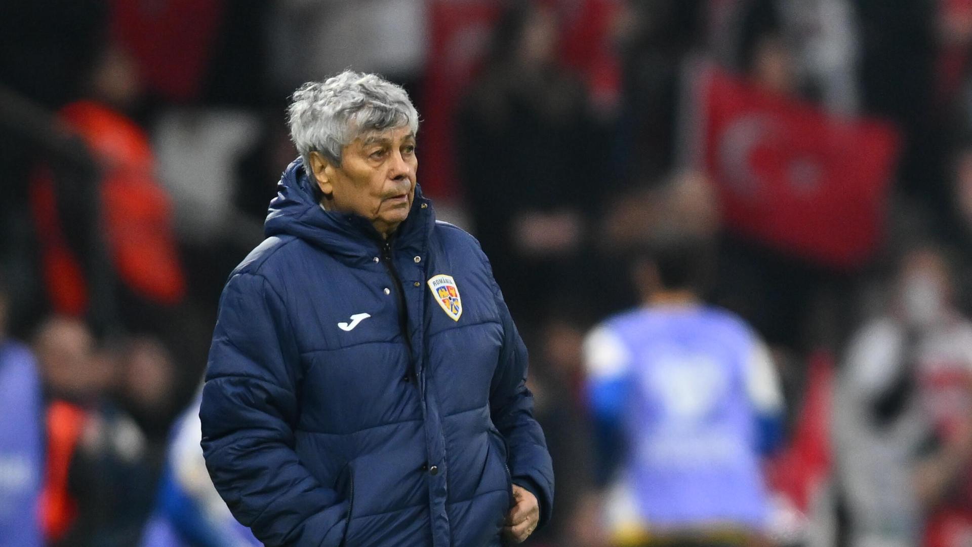 Rumäniens Trainer Mircea Lucescu in dicker Jacke vor verschwommenem Hintergrund.