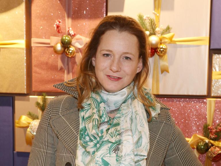 Jenny Falckenberg steht vor verpackten Geschenken 