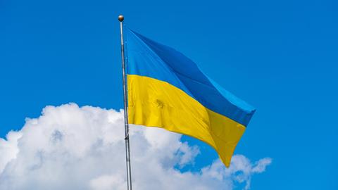 Die Flagge der Ukraine ist vor einem blauen Himmel zu sehen.