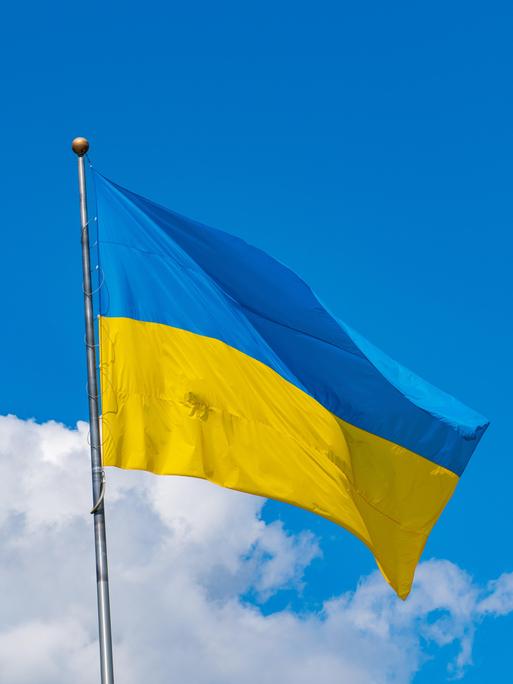 Die Flagge der Ukraine ist vor einem blauen Himmel zu sehen.
