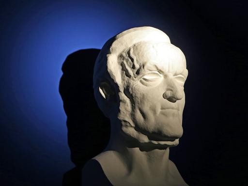 Eine hart angeleuchtete Büste von Richard Wagner vor einem dunkel blauen Hintergrund. Eine hart angeleuchtete Büste von Richard Wagner vor einem dunkel blauen Hintergrund.