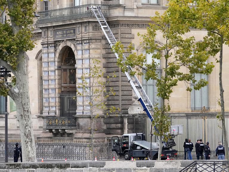 19.10.2025, Paris: Polizisten neben einem Lastenaufzug-Fahrzeug, mit dem Diebe ins Louvre eingestiegen sind.