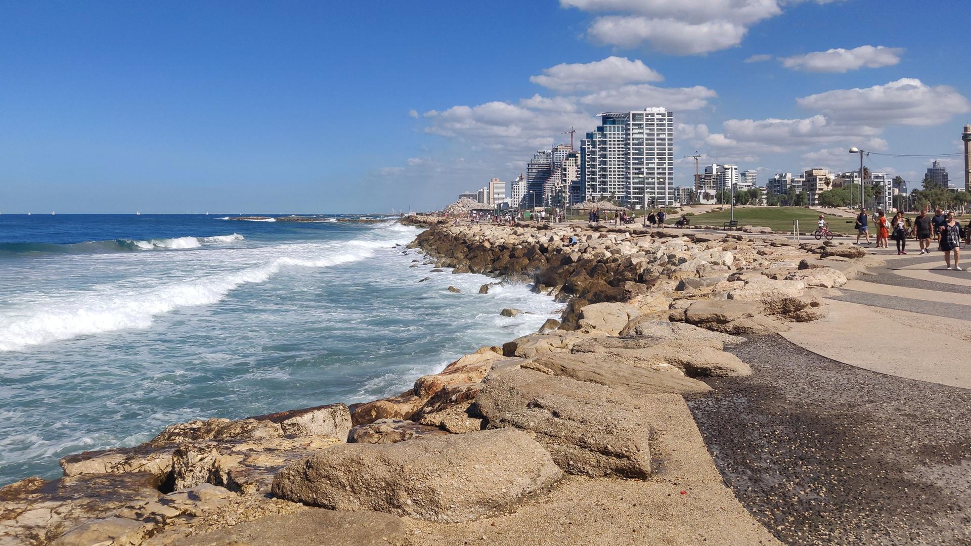 Malerische Aussicht auf die Küste von Tel Aviv mit klarem blauen Himmel, felsiger Küste und modernen Gebäuden im Hintergrund. Malerische Aussicht auf die Küste von Tel Aviv mit klarem blauen Himmel, felsiger Küste und modernen Gebäuden im Hintergrund.