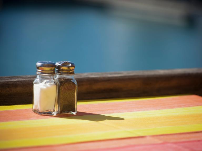 Salz- und Pfefferstreuer stehen auf einem Tisch am Meer.