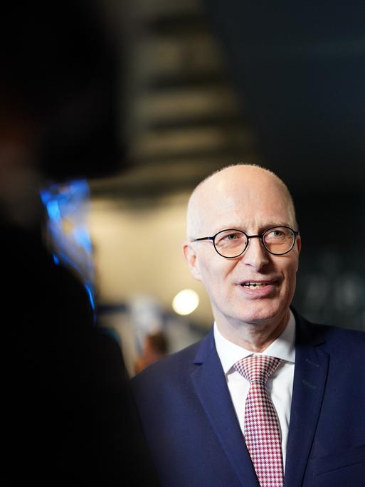 Peter Tschentscher trifft zufrieden lächelnd in einem Fernsehstudio ein.