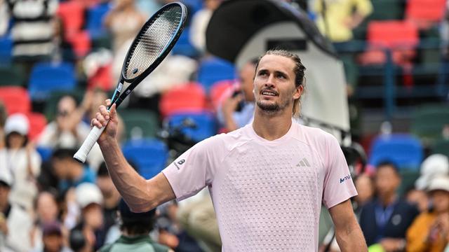 Alexander Zverev winkt mit seinem Schläger in die Zuschauer.
