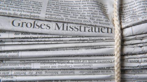 Gebündelter Zeitungsstapel mit Schlagzeile "Großes Misstrauen"