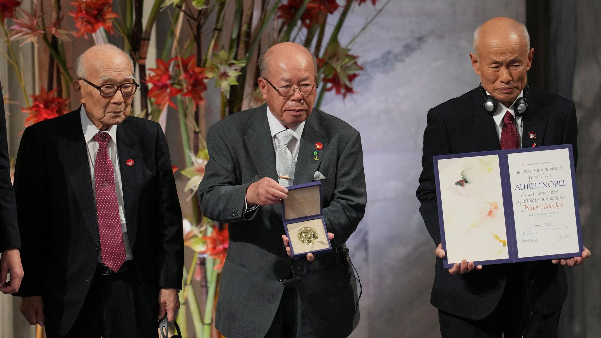 Mitglieder von der japanischen Organisation zeigen stolz ihre Urkunde und die Medaille.