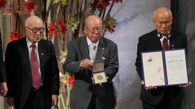 Mitglieder von der japanischen Organisation zeigen stolz ihre Urkunde und die Medaille.