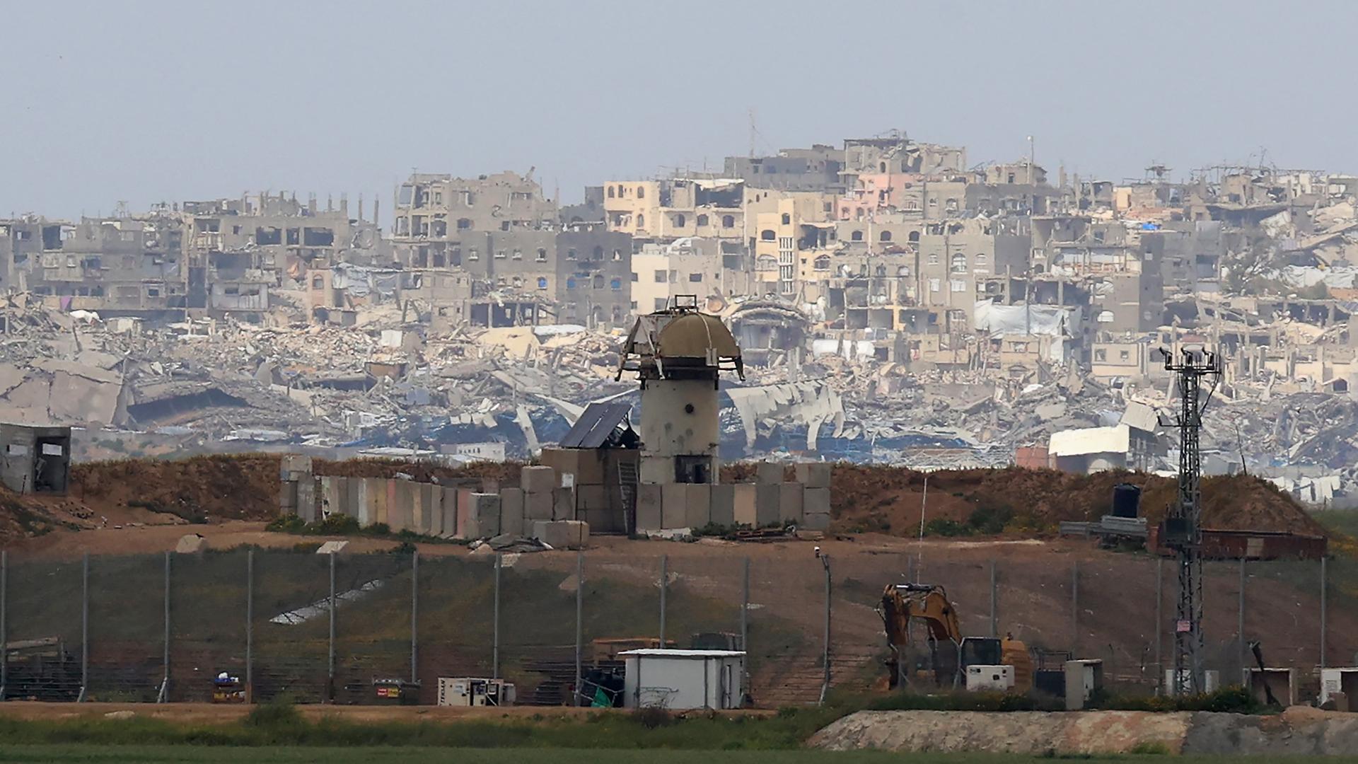 Ein israelischer Militärwachturm steht an der israelischen Grenze zum Gazastreifen. Im Hintergrund sind die Gebäude von Gaza-Stadt zu sehen.