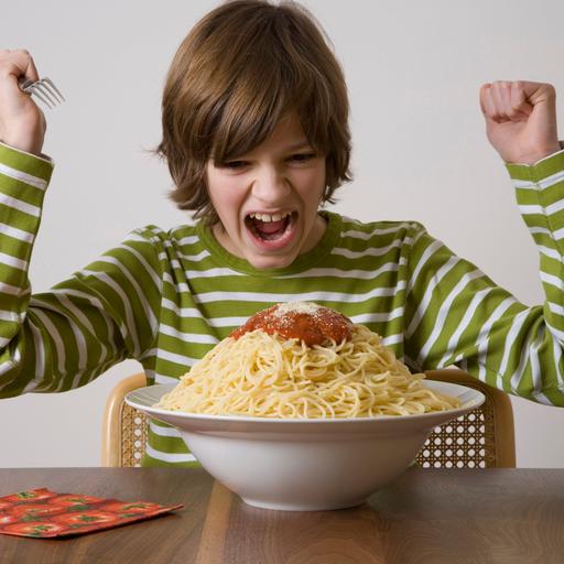 Junge vor einer großen Schüssel Spaghetti