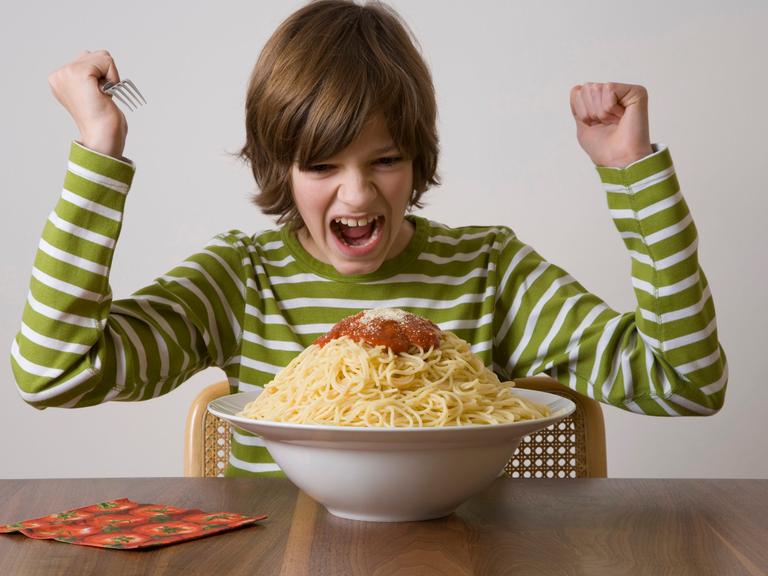 Junge vor einer großen Schüssel Spaghetti