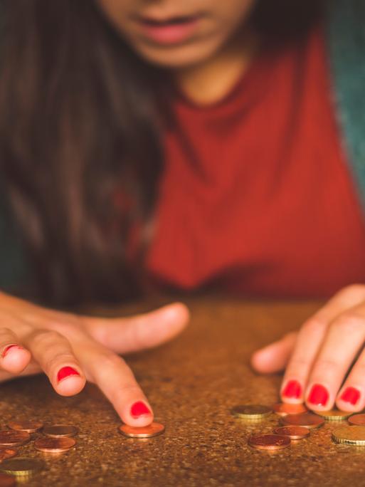 Junge Frau zählt Geld auf dem Tisch