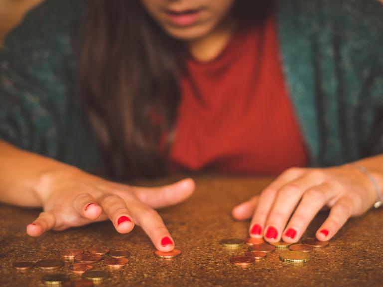 Junge Frau zählt Geld auf dem Tisch