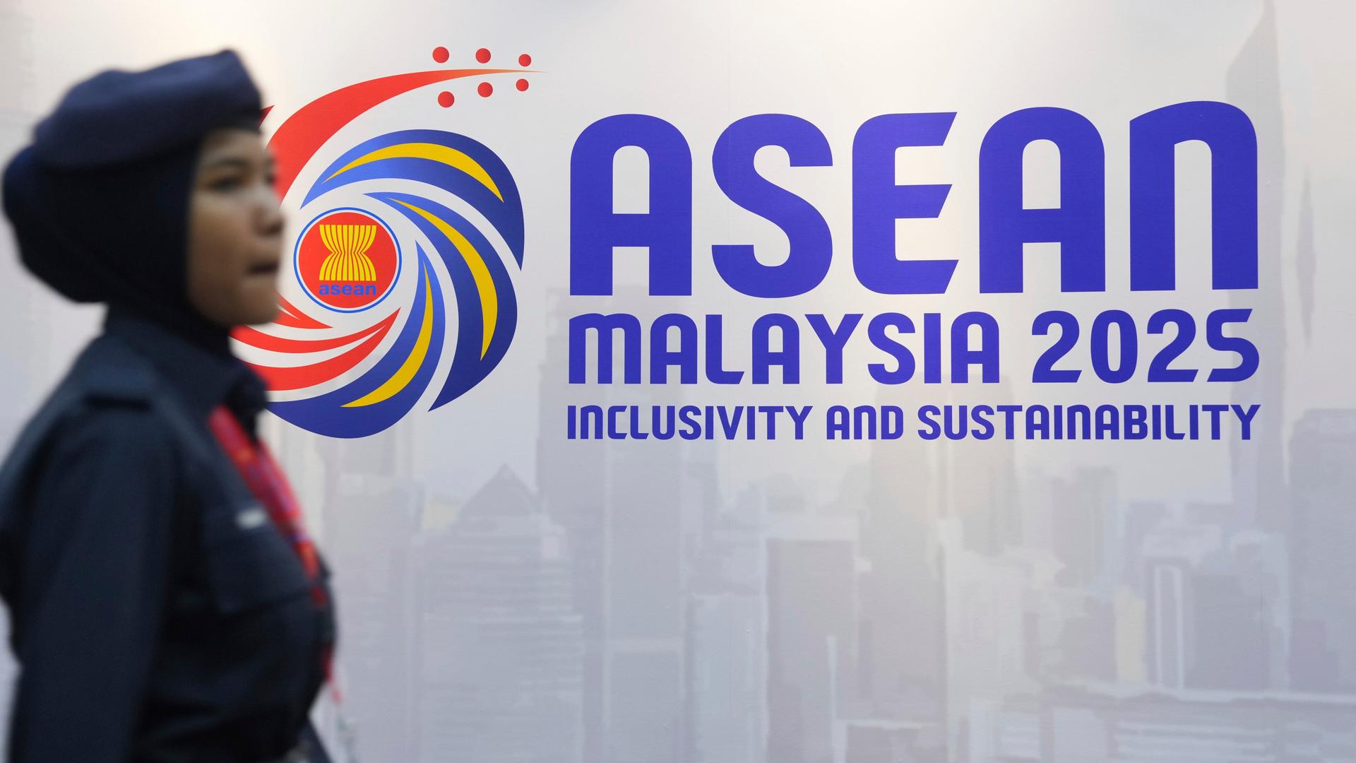 Eine Frau geht am Logo des ASEAN-Gipfels in Malaysia vorbei. Eine Frau geht am Logo des ASEAN-Gipfels in Malaysia vorbei.