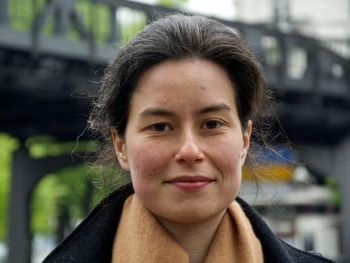 Die Schweizer Autorin Yael Inokai im Porträt. Die dunklen Haare trägt sie hochgesteckt und blickt in die Kamera.  