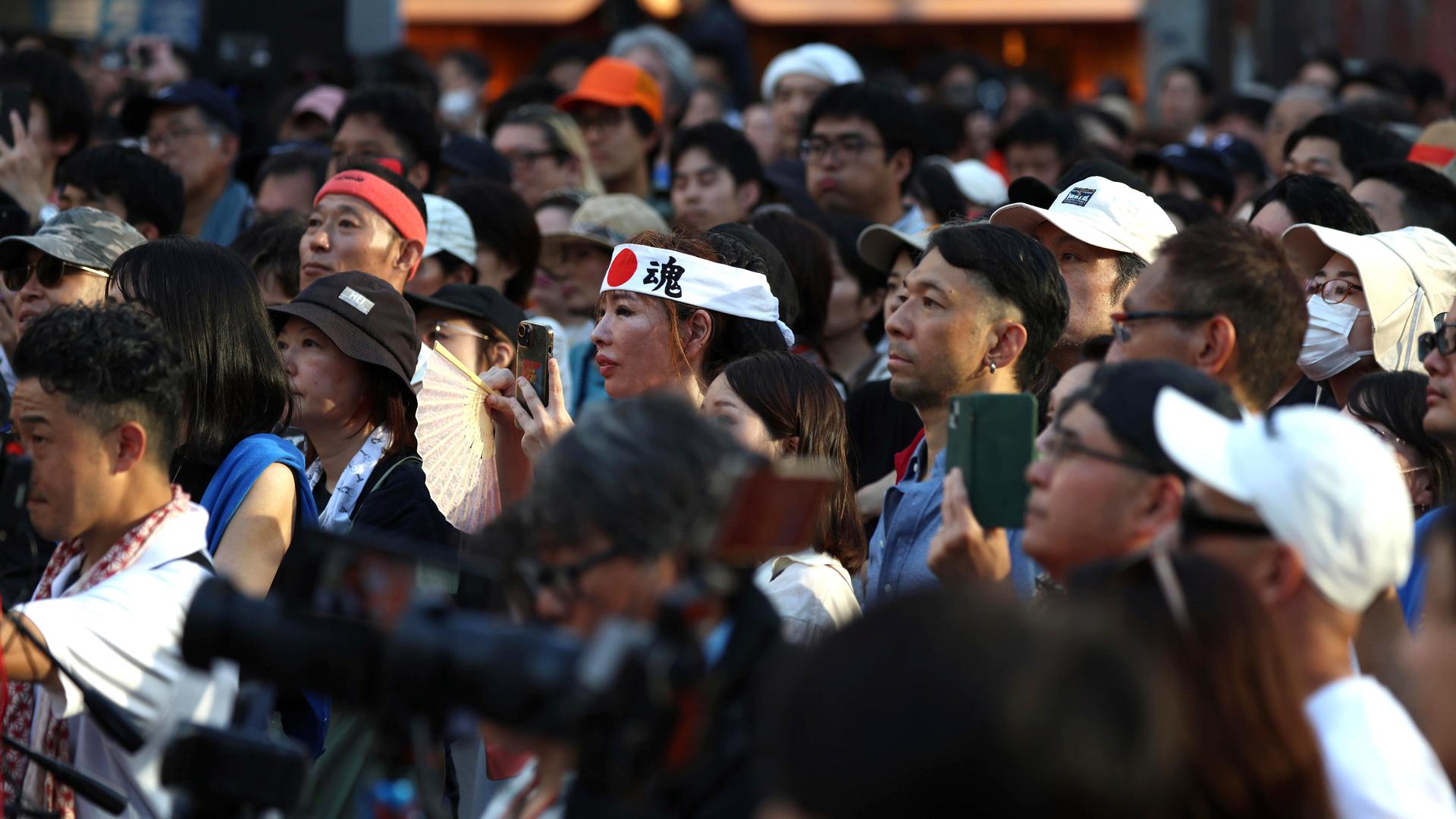 Menschen folgen gebannt einer Rede des Politikers Sohei Kamiya bei einer Straßenkundgebung der rechtspopulistischen Sanseitō-Partei am 21. Juli 2025 in Tokio