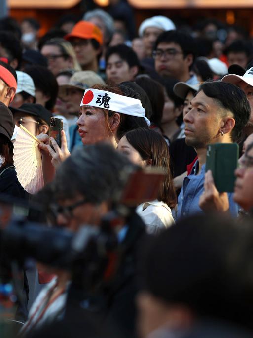 Menschen folgen gebannt einer Rede des Politikers Sohei Kamiya bei einer Straßenkundgebung der rechtspopulistischen Sanseitō-Partei am 21. Juli 2025 in Tokio