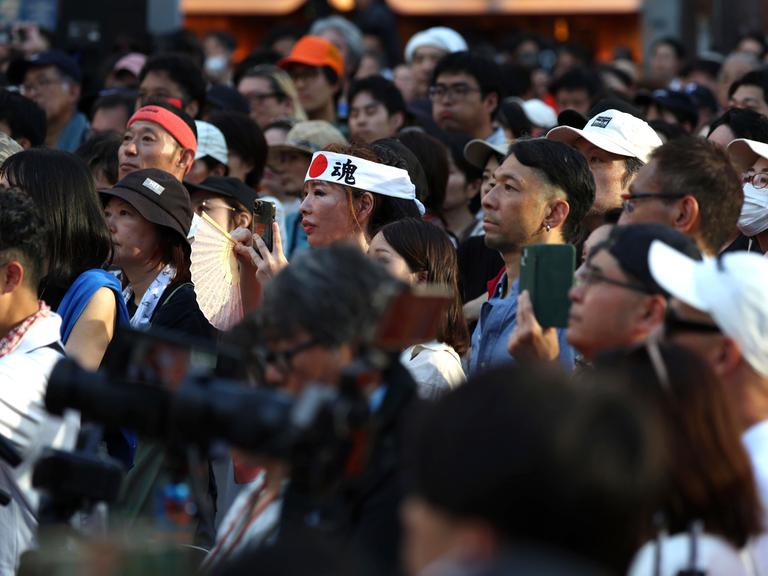 Menschen folgen gebannt einer Rede des Politikers Sohei Kamiya bei einer Straßenkundgebung der rechtspopulistischen Sanseitō-Partei am 21. Juli 2025 in Tokio